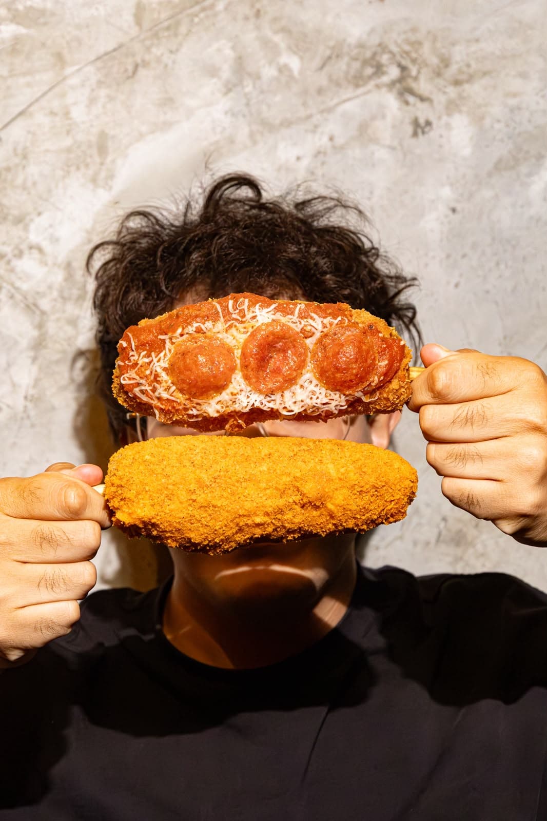 Persona sosteniendo una Chunky Pizza y una Super Cheesy